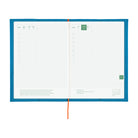An open daily planner with a bright blue cover, white grid pages, and a red ribbon bookmark, photographed on a plain white background.