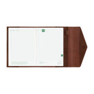 An open brown leather Hobonichi Techo cover with a white grid planner inside, shown against a plain white background.