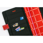 The left interior of a Hobonichi Techo cover featuring black fabric pockets decorated with whimsical illustrations and red accents.