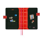 The interior of a Hobonichi Techo cover on a white background featuring a red grid interior and black pockets with whimsical drawings dispersed. It includes pink and red ribbon bookmarks, and red pen closure tabs. 