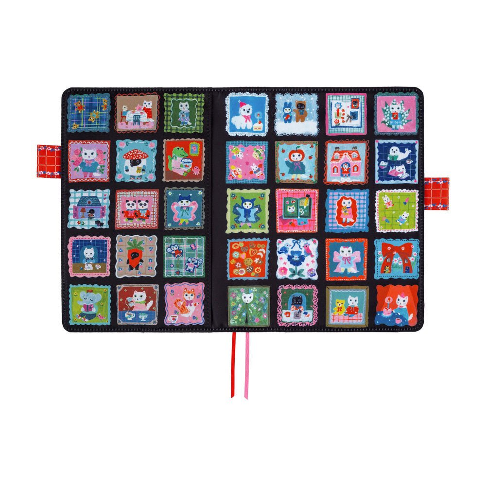 An open, flat  black Hobonichi Techo cover decorated with a colorful grid of patchwork-style square panels, each featuring different whimsical cat illustrations. It has two ribbon bookmarks, one pink and one red, and two red pen closure loops against a plain white background.