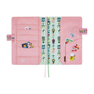 Interior of pink planner cover shown open on a white background, featuring multiple card slots, pockets, and whimsical illustrations of animal characters, houses, and flowers. 