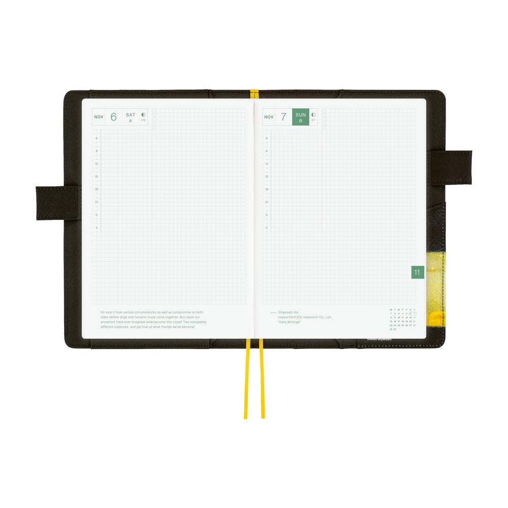 An open weekly planner with white grid pages, a black cover, and yellow ribbon bookmarks shown on a plain white background.
