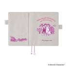 An open Moomin Characters planner cover on a white background, showing a cream-colored cover with pink illustrations and text as well as ribbon bookmarks featuring a flower and shell. The front cover features a Moomin character illustration with the quote 'We'll see for that tomorrow!'