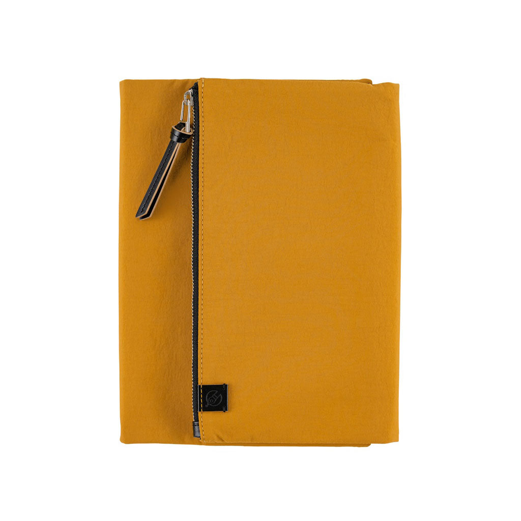 A mustard yellow Hobonichi Tragen tri-fold cover with a vertical zippered pouch and black zipper pull on a plain white background.