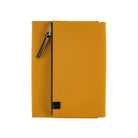 A mustard yellow Hobonichi Tragen tri-fold cover with a vertical zippered pouch and black zipper pull on a plain white background.