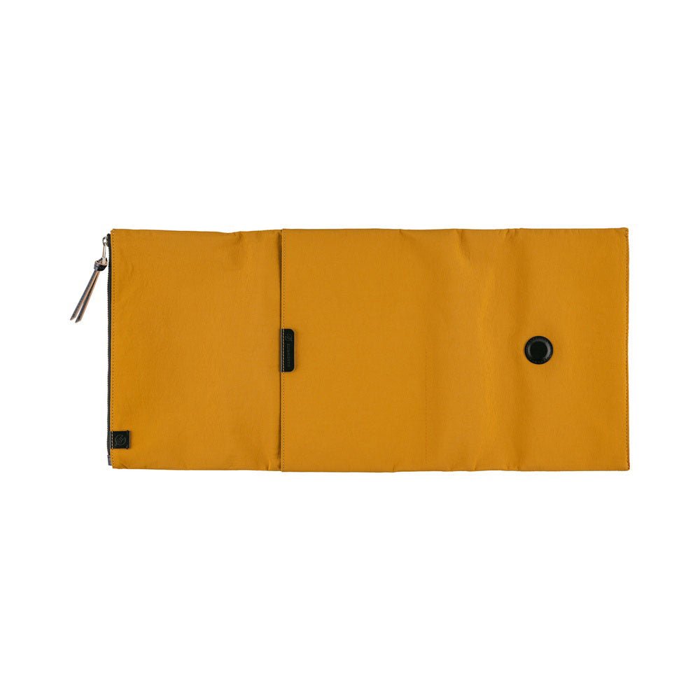 A flat view of a mustard yellow Hobonichi Tragen tri-fold outside cover with a vertical zippered pouch and black zipper pull on a plain white background.
