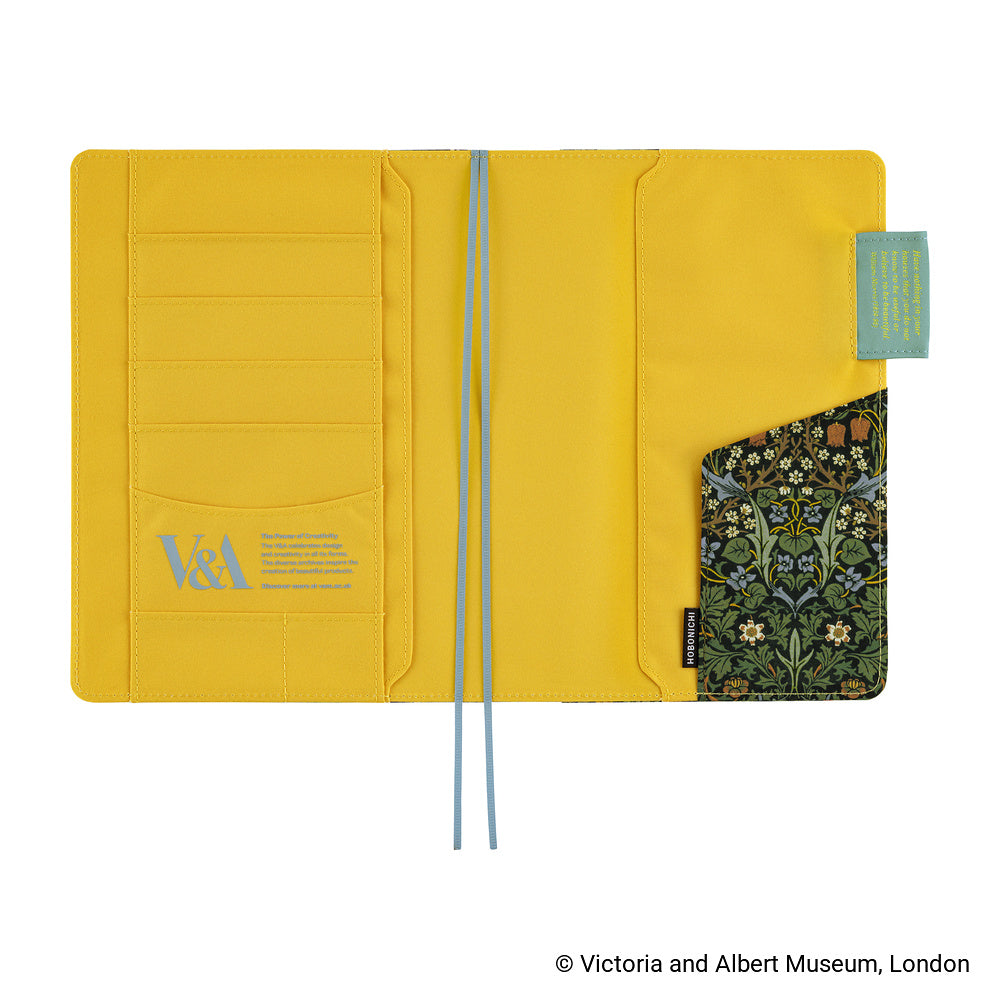 The interior of a Hobonichi Techo cover featuring bright yellow fabric shown open against a white background, with multiple card slots on the left, a patterned pocket on the right, and two light blue ribbon bookmarks hanging from the center.