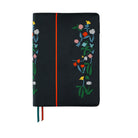 Hobonichi Techo navy planner cover with colorful embroidered flowers on the cover, a vertical red stripe, and ribbon bookmarks in blue and red.
