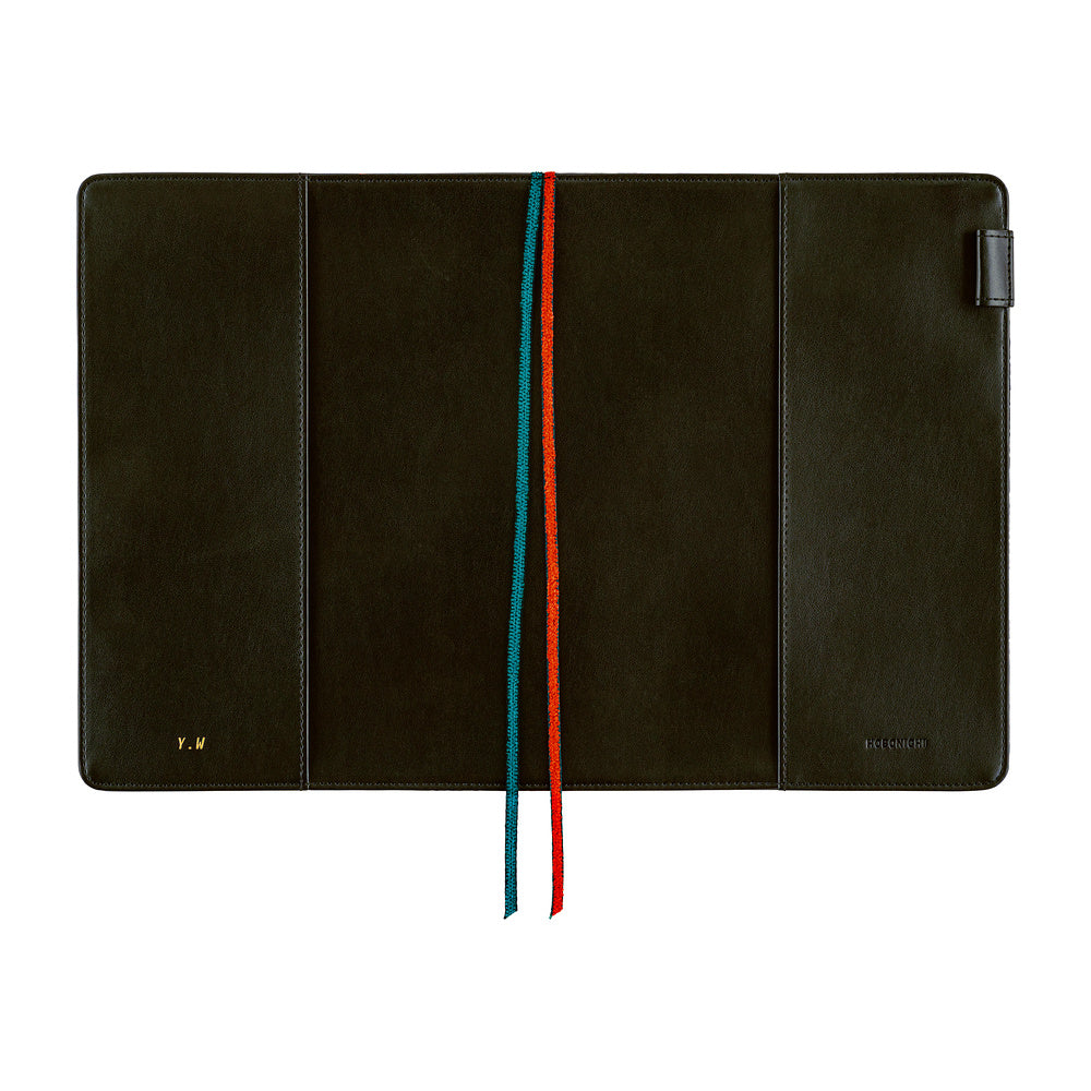 The interior of a Hobonnichi Techo planner cover featuring red and teal ribbon bookmarks and a pen loop all shown against a plain white background.
