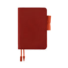 A red leather planner or notebook cover with orange accents, including a side tab and two ribbon bookmarks, shown on a plain white background.