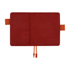 A red notebook cover or planner sleeve shown open flat against a white background, with orange-brown tab loops on the sides and a matching orange-brown drawstring at the bottom.