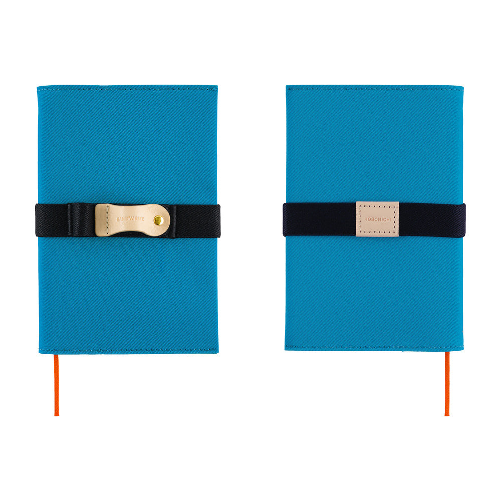 Two blue hardcover notebooks with black elastic bands and gold-tone metal clasps, shown side by side on a white background.