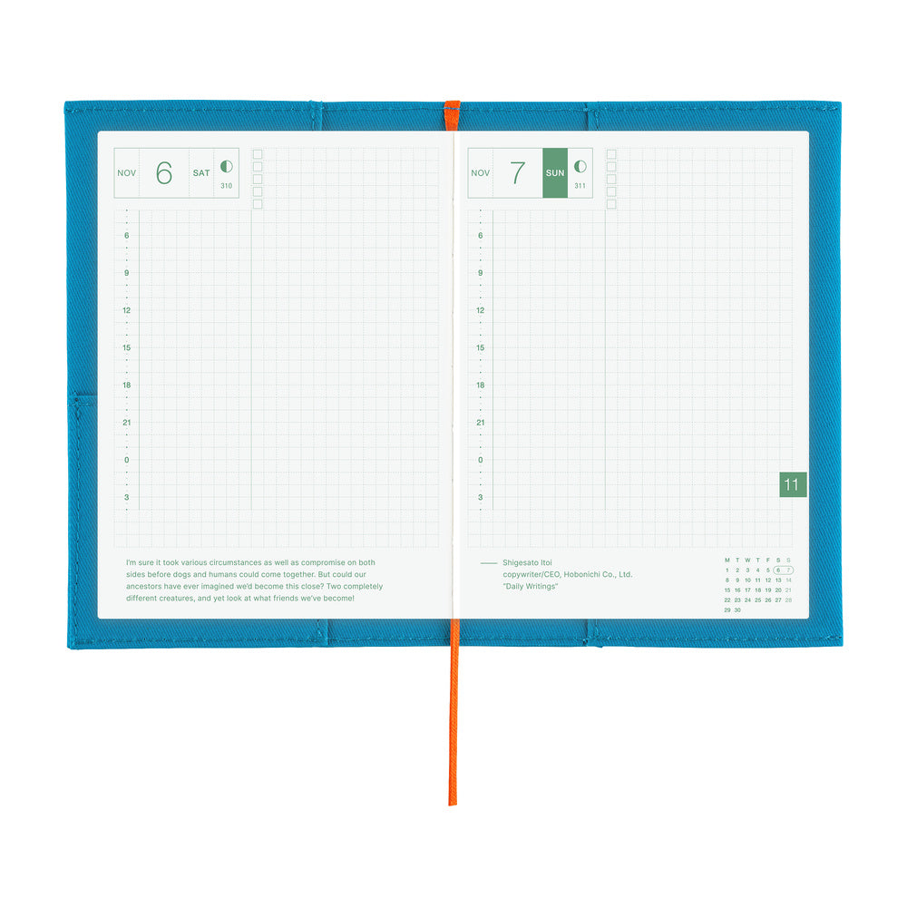 An open two-page planner spread with white grid pages, a bright blue cover border, and an orange elastic closure, photographed on a plain white background.