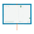 An open two-page planner spread with white grid pages, a bright blue cover border, and an orange elastic closure, photographed on a plain white background.