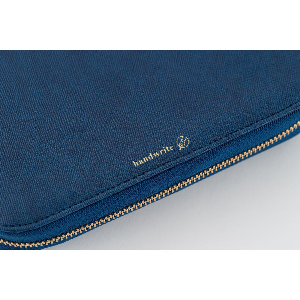 Close-up of a dark blue fabric zippered pouch with a gold zipper and a small gold 'handwrite' logo on the side.