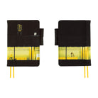 Two black hardcover notebooks with a yellow and black street scene print on the lower half, shown side by side on a white background. Each notebook has a black elastic closure tab and yellow ribbon bookmarks.