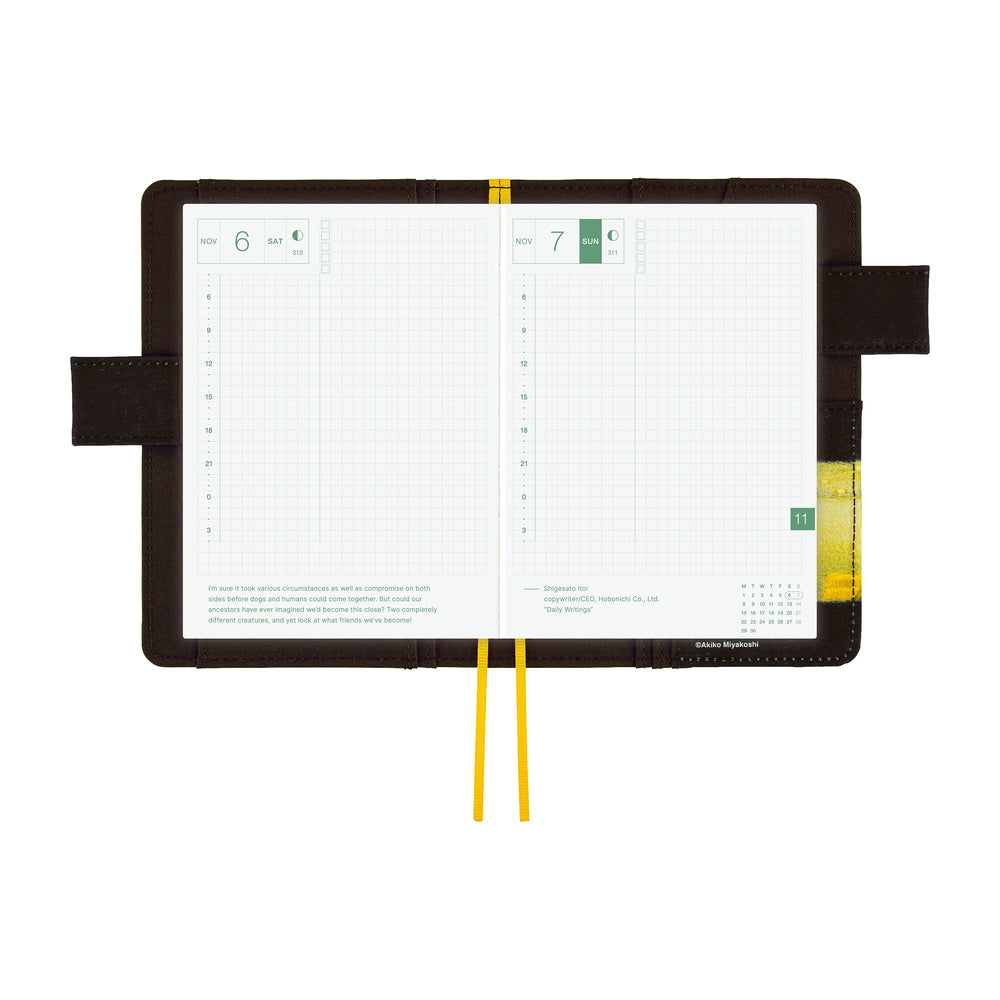 An open weekly planner with grid pages, held by a yellow elastic loop, set against a solid white background.