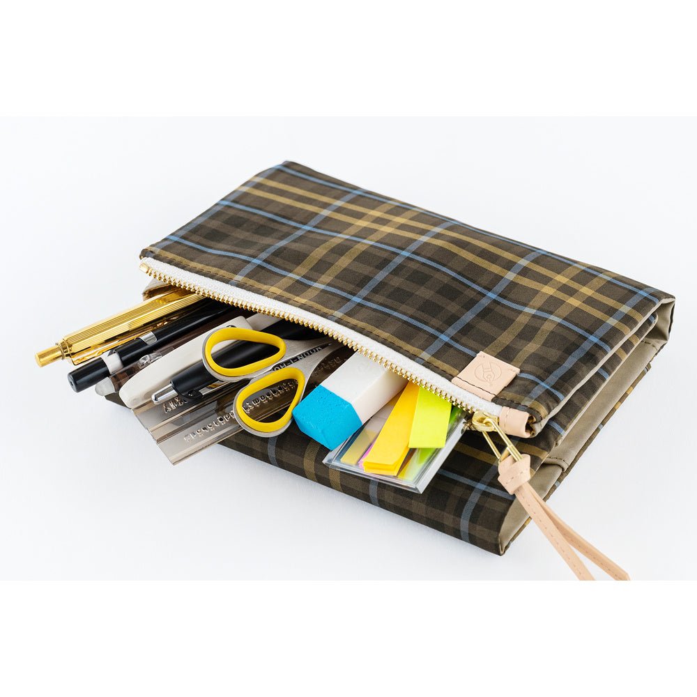 A zippered pencil case with a brown and beige plaid pattern, shown open with various stationery items like pens, scissors, and highlighters peeking out. The case has a light tan wrist strap and is photographed on a clean white background.
