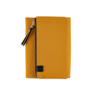 A mustard yellow zippered pouch or sleeve with a black zipper, black leather tassel, and a small black square logo patch on the front, shown against a plain white background.