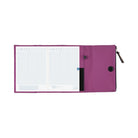An open purple Hobonichi Tragen tri-fold cover holding a gridded planner, with interior pockets, pen holder, magnetic closure, and zippered pouch visible on a plain white background.