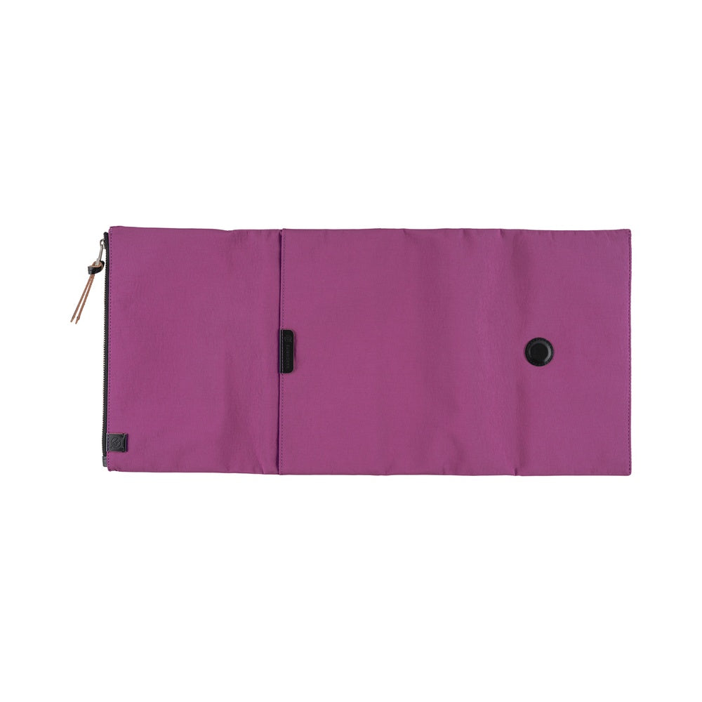 A flat view of a purple Hobonichi Tragen tri-fold outside cover with a vertical zippered pouch and black zipper pull on a plain white background.