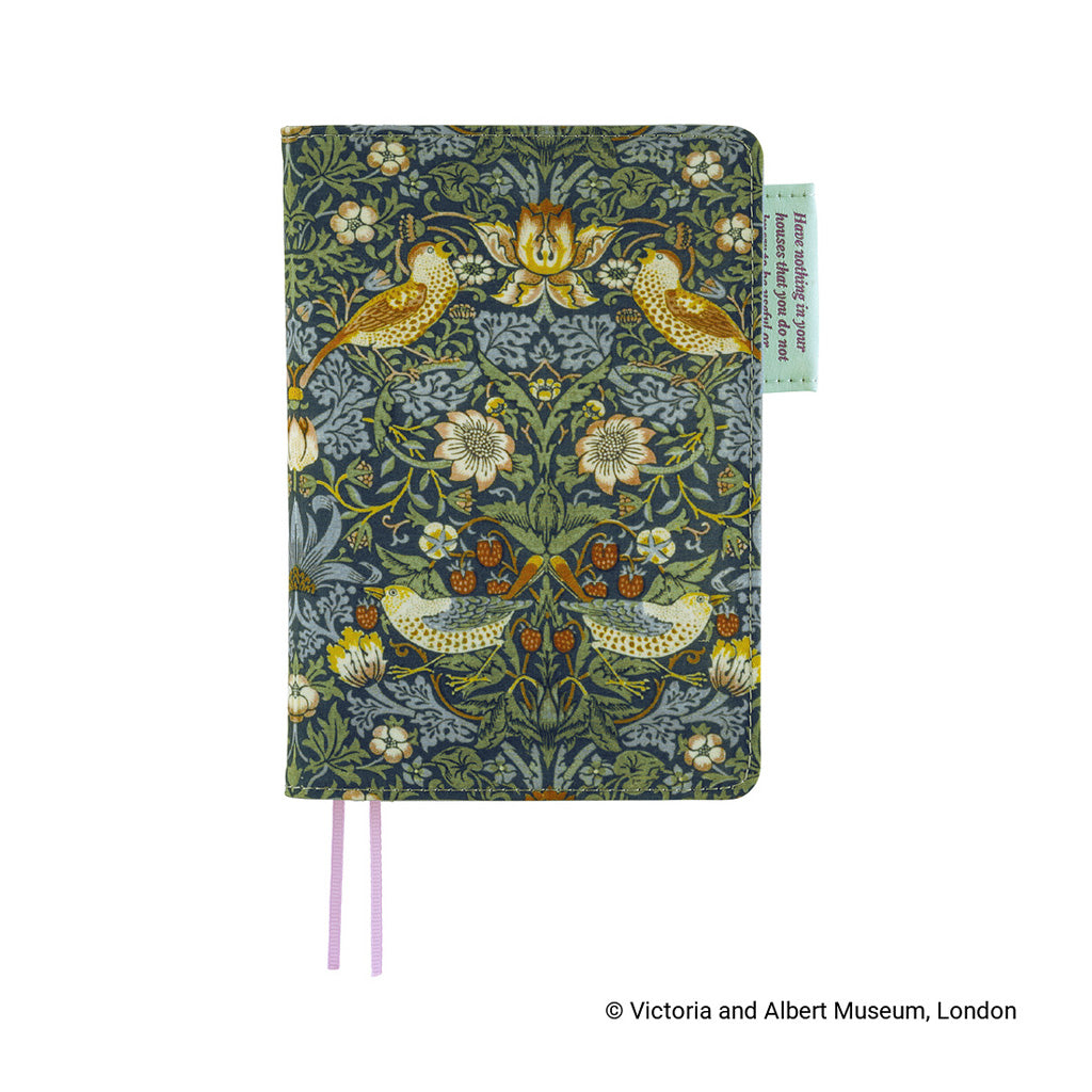 A hardcover journal featuring a detailed William Morris-style floral and bird pattern in muted green, blue-gray, and ochre tones, with two pink ribbon bookmarks and a small light green paper tag on the right side.