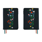 Two black journal covers with colorful embroidered wildflowers, shown side by side on a white background.