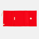 Red fabric Tragen zippered cover for Hobonichi Techo Cousin A5 planner on white background