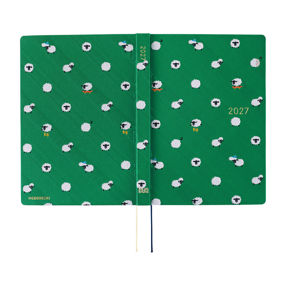 A 2027 Hobonichi Techo HON hardcover laid flat to show a bright green design covered with playful white sheep, with two ribbon bookmarks on a white background.