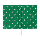 A 2027 Hobonichi Techo HON hardcover laid flat to show a bright green design covered with playful white sheep, with two ribbon bookmarks on a white background.