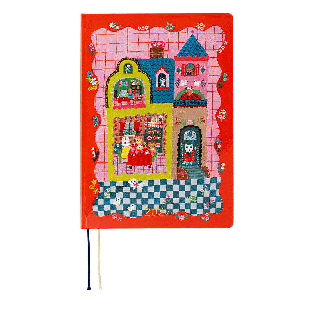 A red 2027 Hobonichi Techo HON hardcover planner featuring Yumi Kitagishi’s colorful dollhouse illustration with cats, rabbits, flowers, and other playful details on a white background.