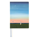 A 2027 Hobonichi Techo HON hardcover planner featuring Hiroko Kubota’s illustration of a cat and wolf using a string telephone across a grassy meadow at sunset, with a mouse riding a unicycle along the line beneath a starry sky and crescent moon.