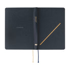 A dark navy 2027 Hobonichi Techo HON hardcover laid flat, featuring a gold-embossed slash motif and two ribbon bookmarks on a white background.