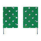A 2027 Hobonichi HON covered in Bow & Tie fabric woven with a sheep design on a green background