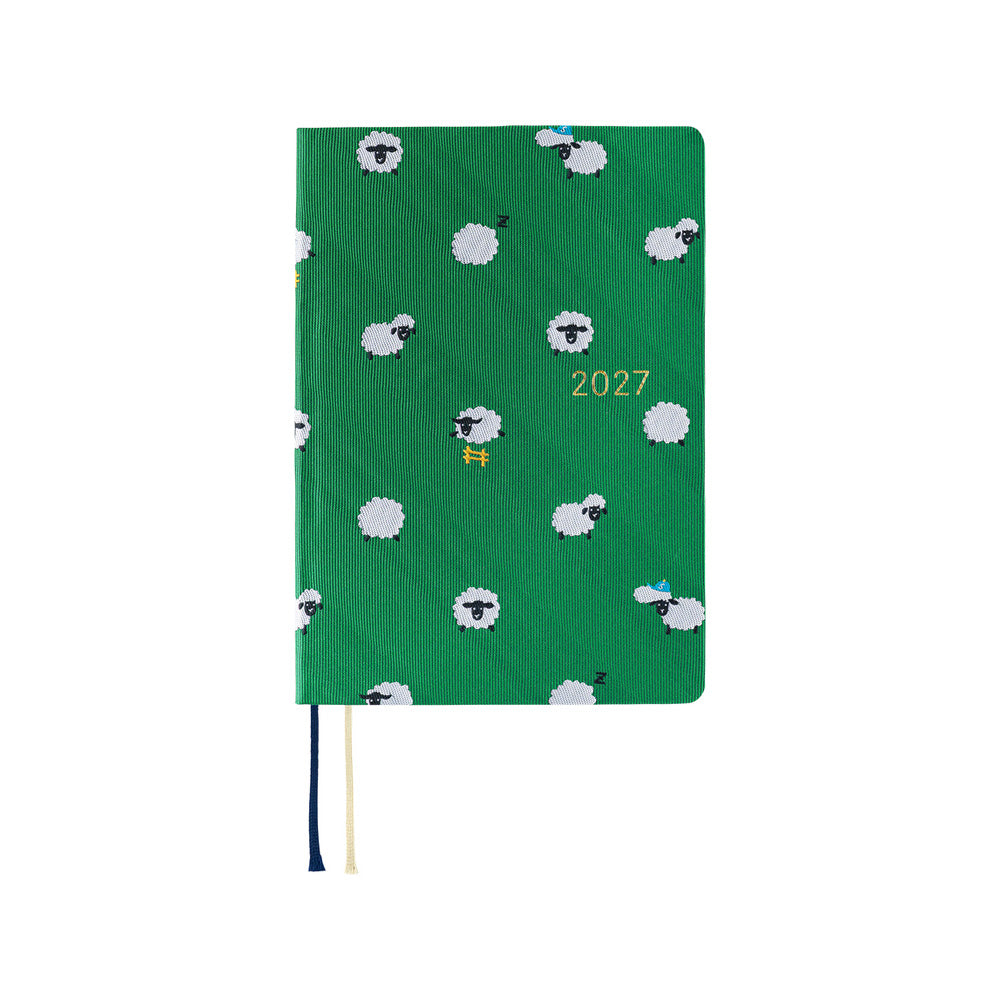 A 2027 Hobonichi HON covered in Bow & Tie fabric woven with a sheep design on a green background