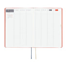 An open weekly planner with a red hardcover, white grid pages, and two ribbon bookmarks, shown on a plain white background.