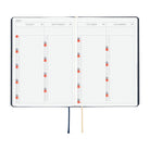 An open planner or calendar showing the months August through November 2027 on two inner pages, with a dark cover edge visible, a navy ribbon bookmark, a cream ribbon bookmark, and small colored date markers. The product is photographed on a plain white background.