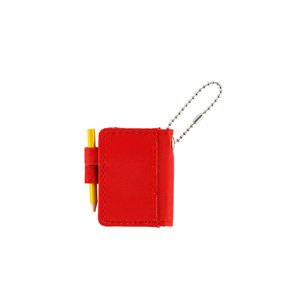 Back of small red notebook keychain with a silver ball chain and a red loop holding a yellow pencil, shown on a plain white background.