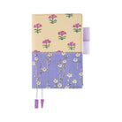 Front of Hobonichi Techo A6 Original Unsodo Book in ivory and purple floral cover with purple pen loops on white background