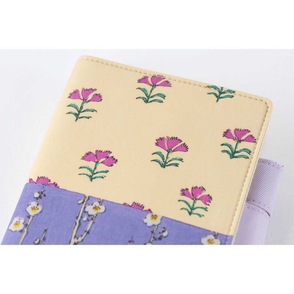 Close up of front of Hobonichi Techo A6 Original Unsodo cover with purple and ivory floral design on white background