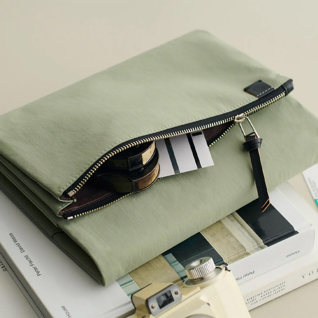 Green zippered pouch open with accessories inside