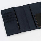 A black fabric organizer pouch shown open on a clean white background. The left side features multiple horizontal card slots, and the right side has a large pocket with a small black label patch.