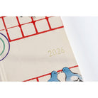 Close up of Hobonichi Techo Weeks Unsodo Spring Start Weeks planner with 2026 year embossed on front cover on white surface