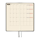 An open planner featuring a monthly two-page calendar on cream colored paper.