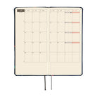 An open planner showing a monthly calendar spread for June with cream grid pages