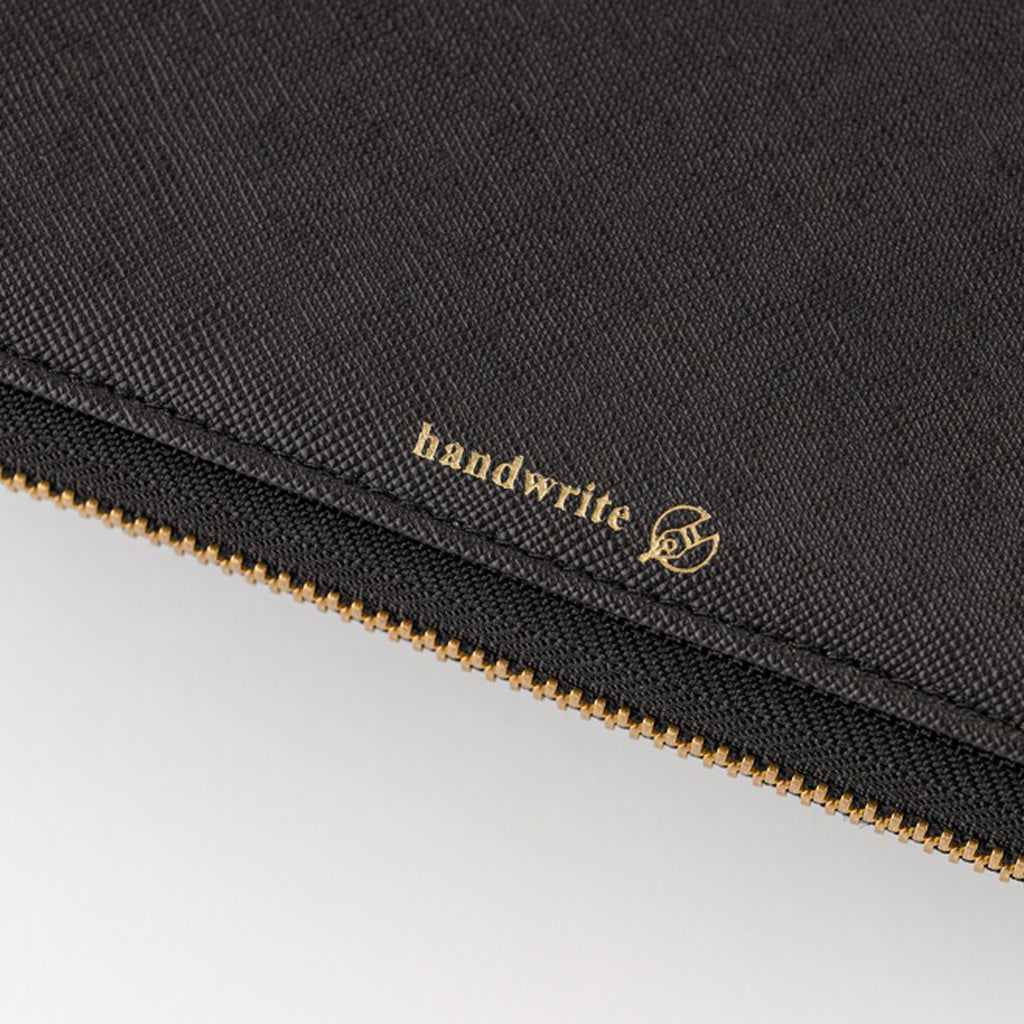 Close-up of a black textured fabric pouch with a gold zipper and gold 'handwrite' logo printed on the side, set against a light gray background.