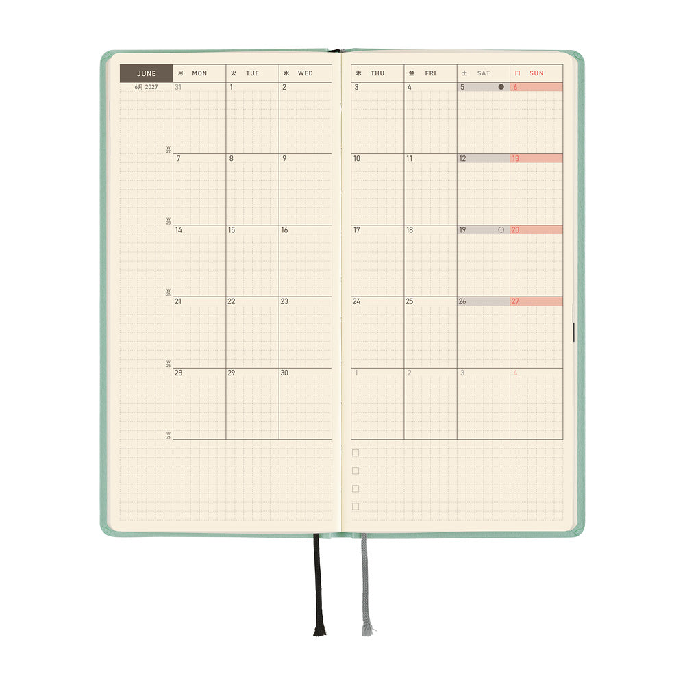 An open planner showing a monthly spread with grid pages, a mint green cover, and ribbon bookmarks, shown on a plain white background.