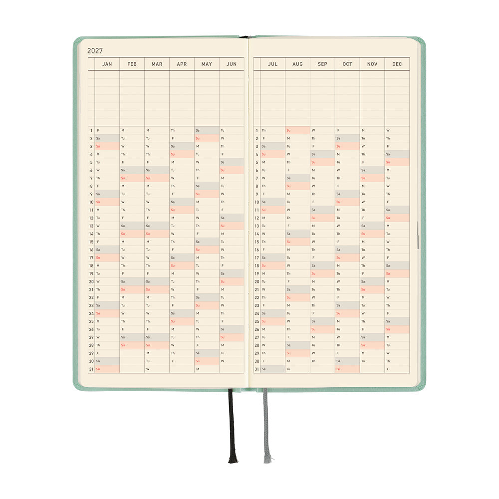 An open 2027 planner with a frosty green cover, showing a yearly calendar spread on cream pages.