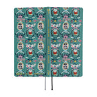 The exterior of a teal planner featuring illustrations of a White Cat character as well as geese. 